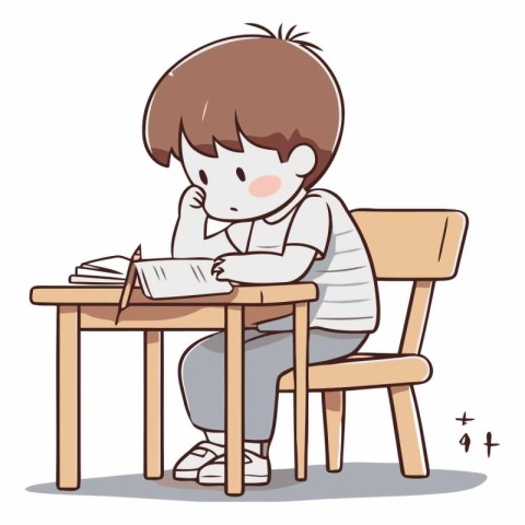 Boy studying at the table and writing in notebook.