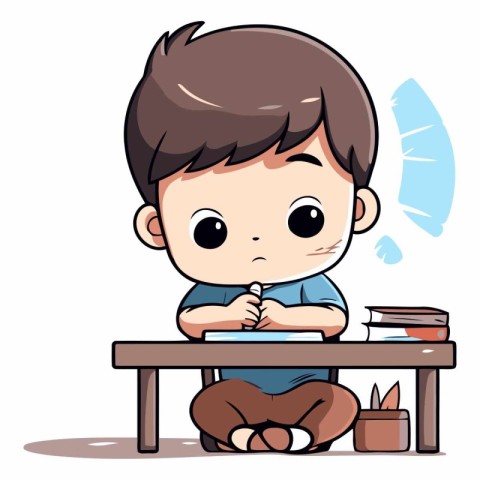 Cute little boy sitting at the desk and writing