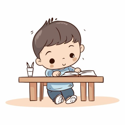 Cute little boy reading a book at the table.