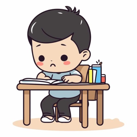 Cute little boy sitting at the table and doing homework.