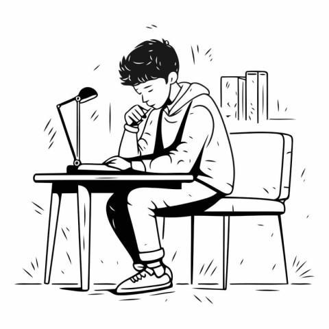 Teenager boy sitting at the desk with laptop.