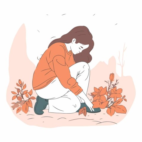 Young woman sitting on the ground and looking at flowers