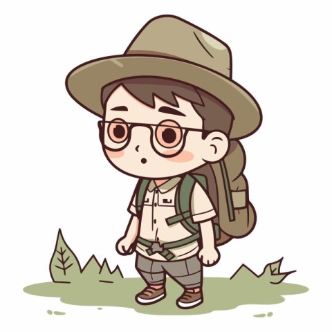 Boy scout with hat and glasses standing in the grass.