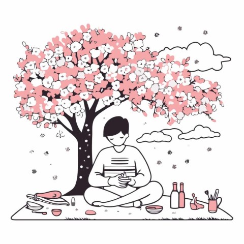 Young man reading a book under a cherry tree.